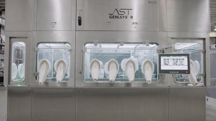 Front view of isolated GENiSYS R aseptic small batch filling and closing machine, showing glove ports and the ASTView human-machine interface (HMI).