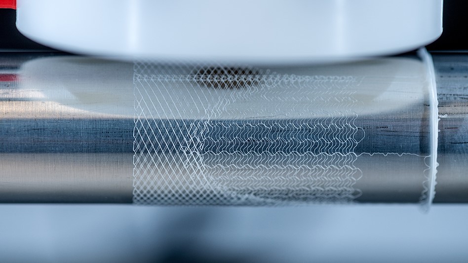 Close-up of a cylinder in a melt electrowriting system showing a printed heart valve scaffold.