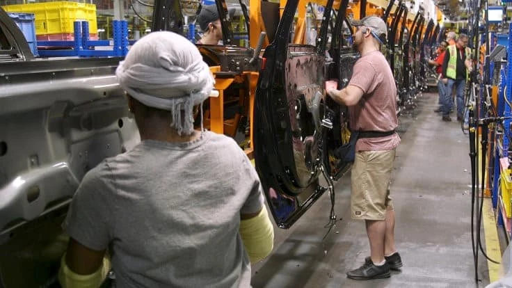 Workers at Ford's Kentucky Truck Plant in Louisville hang doors on Lincoln Navigator SUVs. The automaker hopes to reopen that plant on April 14.