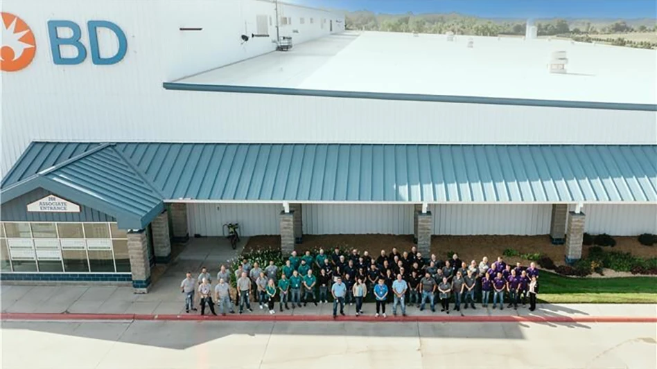 A group of people standing in front of a factory