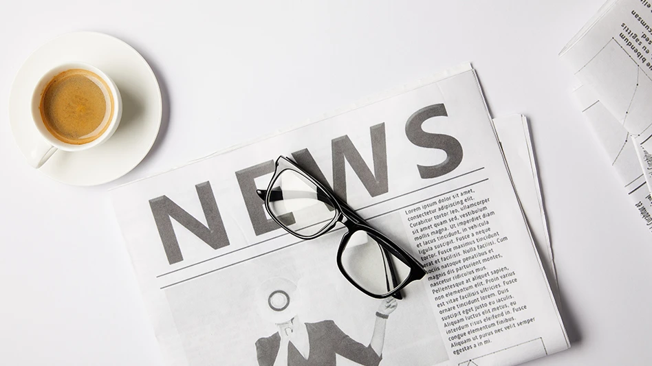 A newspaper, glasses and a coffee cup