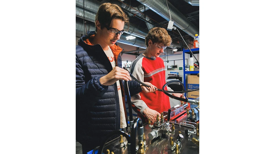Two students work on a mechanical project